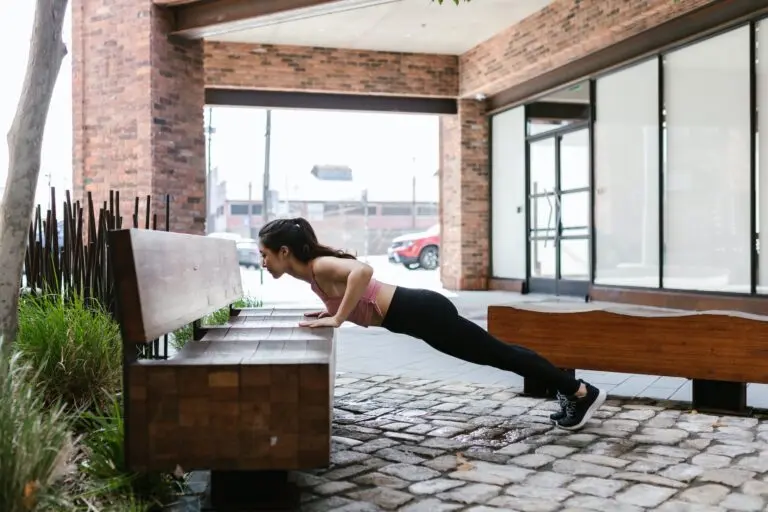 a woman in pink tank top doing a push up